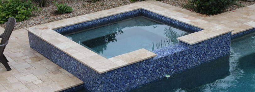 Bright blue mosaic-patterned hot tub overlooking pool by New Image's Mesa & Scottsdale pool service
