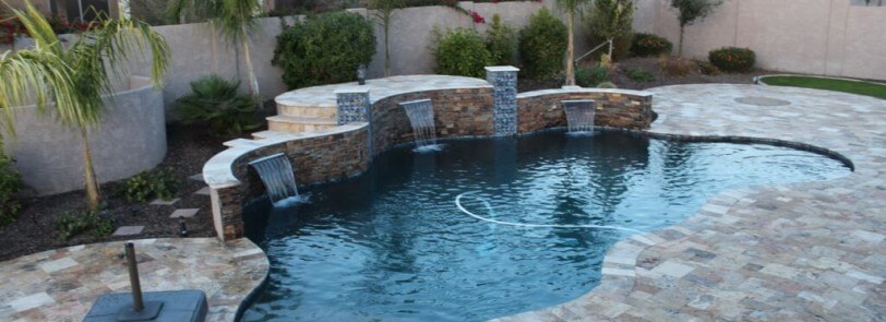 Custom-shaped pool with elevated platform structure with three built-in waterfalls by New Image's Mesa & Scottsdale pool service